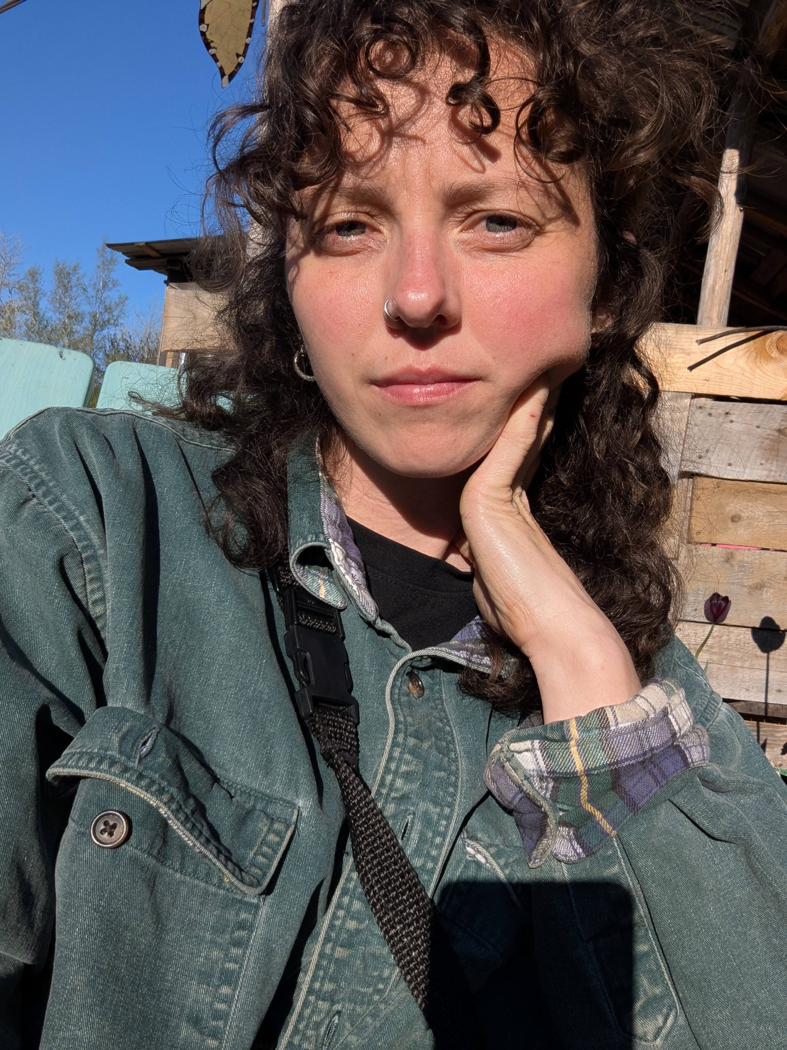 Azra sitting outside with the sun in their eys